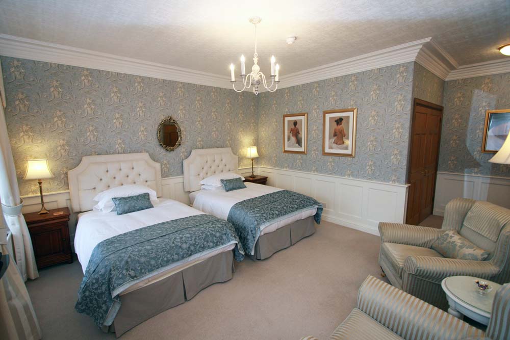 The Georgian Room with two wide beds and pale blue furnishings